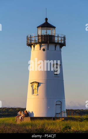 People enjoy the sunrise at Edgartown Harbor Light in Edgartown, Massachusetts on Martha's Vineyard. Stock Photo