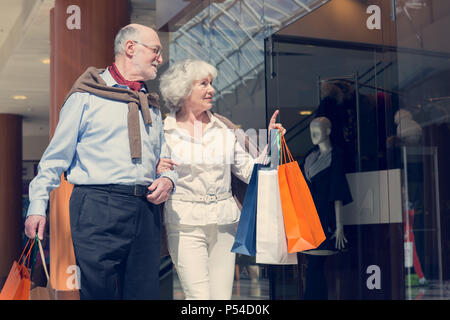 Adult senior couple with purchases in bags at shopping mall Stock Photo