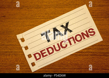 Writing note showing  Tax Deductions. Business photo showcasing Reduction on taxes Investment Savings Money Returns Text two word white paper note woo Stock Photo
