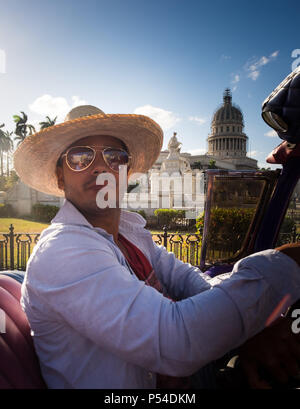 HAVANA, CUBA - CIRCA MAY 2016: Taxi driver of old convertible classic car driving through the Capitol in Havana Stock Photo