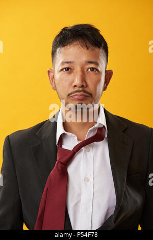 Overwork young asian man portrait isolated on yellow background Stock Photo