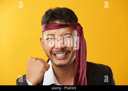Portrait of happy asian young man isolated on yellow background Stock Photo