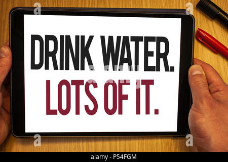 Handwriting text Drink Water. Lots Of It. Concept meaning drinking liquids to keep our body in great status Hand hold showing colorful letters black m Stock Photo