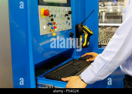 Operator working with industrial laser cutting machine through the CNC interface. Selective focus. Stock Photo