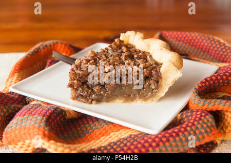 One slice of Thanksgiving pecan pie on a square white plate Stock Photo