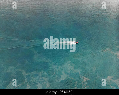 Top view of a white boat sailing in the blue sea. Top view of the boat ...