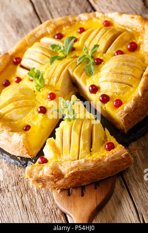 Piece of homemade apple pie with cranberries and custard close-up on the table. vertical Stock Photo