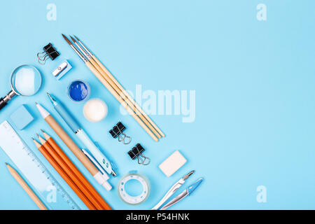 Stationary on blue background. Pens, pencils, ruler, paints, paintbrushes and other. Knolling concept. Stock Photo