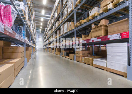 Interior view of aisles in a large warehouse stacked with cardboard boxes Stock Photo