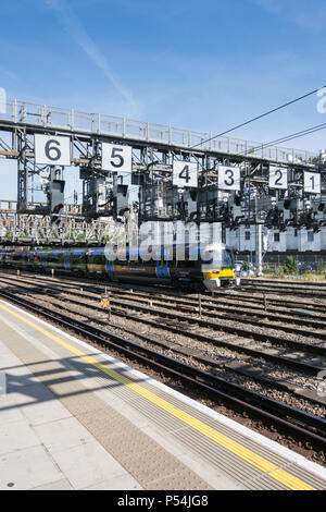 A Heathrow Express train passing under the Royal Oak signalling gantry on leaving Paddington Station, London, UK Stock Photo