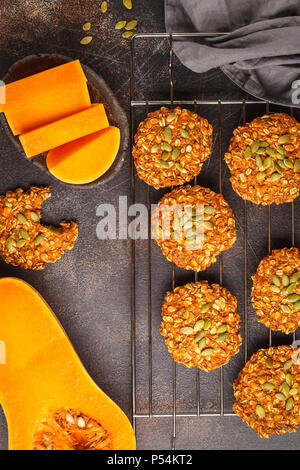 Vegan oatmeal pumpkin cookies from oven on dark background, halloween food, autumn food, vegan food concept. Stock Photo