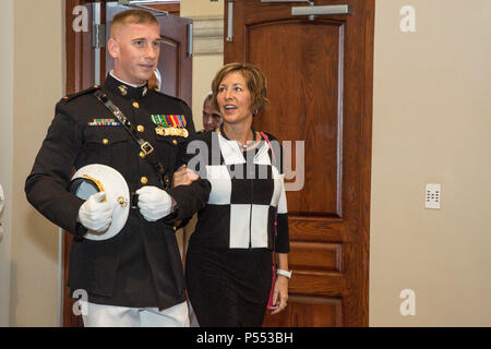 U.S. Marine Corps Chief Warrant Officer 2 Richard H. Woodall, personnel officer, Marine Barracks Washington, escorts a guest to her seat during the retirement reception of Lt. Gen. Robert R. Ruark, deputy, Under Secretary of Defense for Personnel and Readiness, at Marine Barracks Washington, Washington, D.C., May 10, 2017. Ruark retired after 36 years in the U.S. Marine Corps. Stock Photo