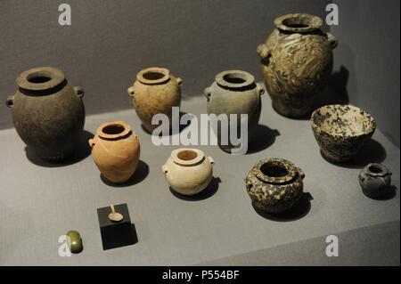 Stone jars and bowls with a small spoon and a small grinding stone with may have been used with a cosmetic palette. Tombs from Gerzeh, Egypt. Predynastic Era. C. 3500-3300 BC. Ny Carlsberg Glyptotek. Copenhagen. Denmark. Stock Photo