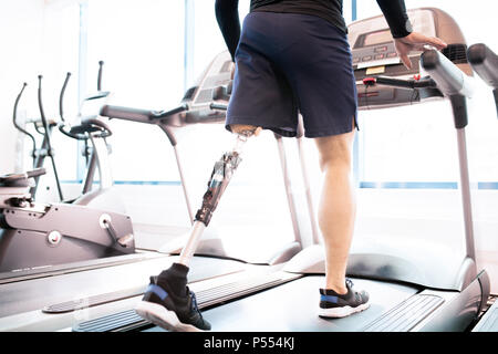 Handicapped Muscular Man Running on Treadmill Stock Photo