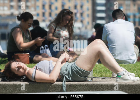 London, UK. 25th June 2018. UK Weather: A woman sunbathes in Potters Field  London on a hot day as  Britain heads into a mini heatwave, with temperatures forecast to hit mid  30º Celsius by Wednesday  next week Credit: amer ghazzal/Alamy Live News Stock Photo