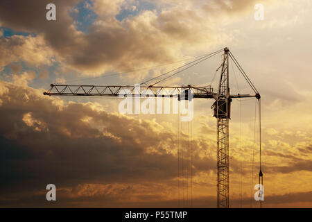 Tower crane on a construction site at sunrise. Stock Photo