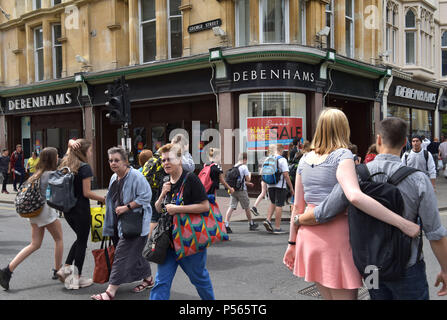 Shoppers and tourists walk past the department store Debenhams on the corner of the high street, George Street in Oxford Stock Photo