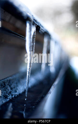 Icicles hanging from gutter Stock Photo