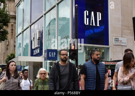 Shoppers, tourists and office workers walk past the flagship Gap store on Oxford Street in central London Stock Photo