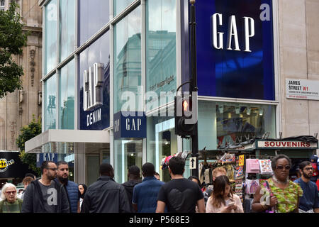 Shoppers, tourists and office workers walk past the flagship Gap store on Oxford Street in central London Stock Photo