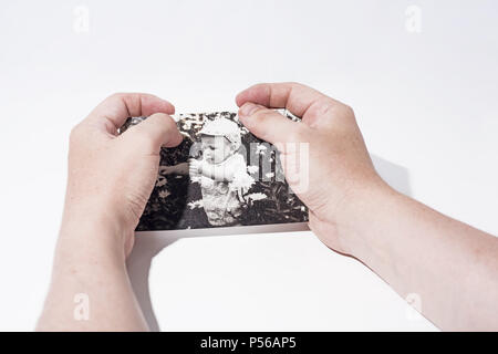 Old paper photo in mans hands. Abstract photo of childhood. Stock Photo