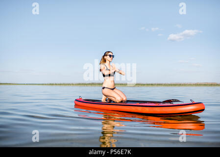 Woman doing yoga on the paddleboard Stock Photo
