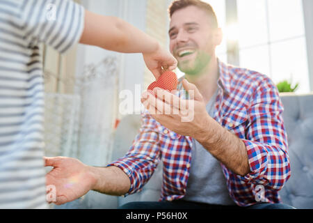Warm toned portrait of unrecognizable little boy giving toy heart to smiling dad congratulating him on fathers day or Valentines day, copy space Stock Photo