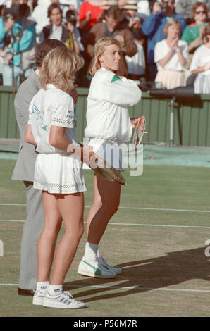 Steffi Graf pictured holding her winners trophy, and Martina Navratilova with her runners up trophy. Between them is Alan Mills, The Wimbledon Referee.  Steffi Graf beats current 6 times defending champion Martina Navratilova, to win the Wimbledon Ladies Singles Final on 2nd July 1988.    After Graf took a 5-3 lead in the first set, Navratilova won six straight games allowing her to win the first set and take a 2-0 lead in the second set. Graf then came back winning 12 of the next 13 games and the match.  Steffi Graf's first of 7 Wimbledon singles title wins. 1988, 1989, 1991, 1992, 1993, 1995 Stock Photo