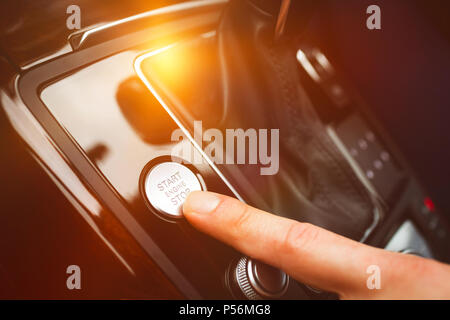 Man pressing start button in car Stock Photo