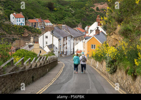 Young couple walking down to the picturesque village of Staithes, North Yorkshire, England. Stock Photo