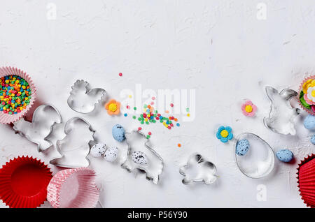 cookie cutter in shape of symbol of Easter - Bunny, egg, chicken, colorful eggs and sugar sprinkles for cookies and cakes, top view, copy space Cookin Stock Photo