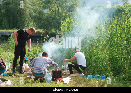 June 12, 2018, Kaliningrad region, Russia, tourists cook at the campfire, campfire travelers on the lake Stock Photo