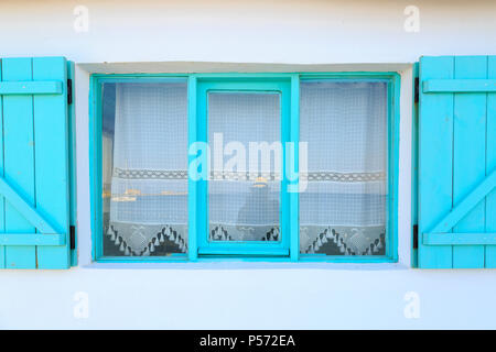 Turquoise framed windows on white wall with curtains in Datca, Turkey Stock Photo