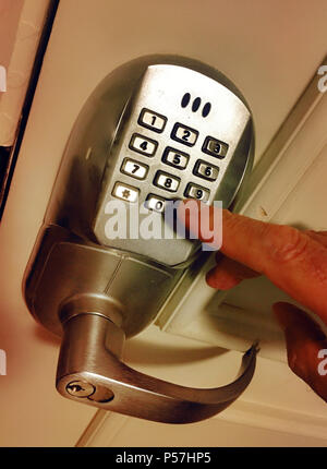 Close up of man pushing buttons on electronic keypad to open a door, United States. Stock Photo