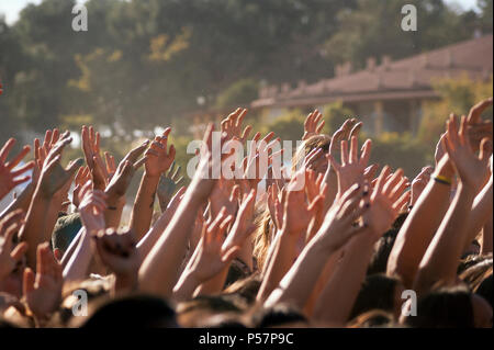 Crowded people hands up at a day time concert. Stock Photo
