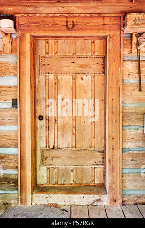 Old antique wooden door in a vintage log cabin with a horseshoe over the door in rural Alabama, USA. Stock Photo