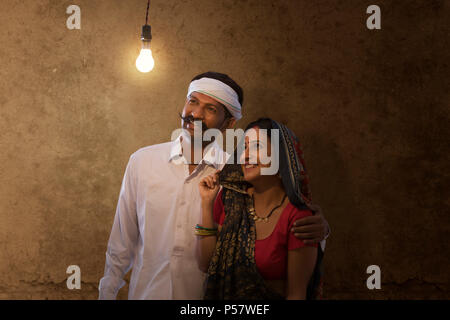 Rural couple looking at light bulb in house Stock Photo