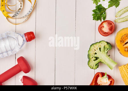 Bell pepper with measuring tape, dumbbells and bottle of water, isolated on white Stock Photo
