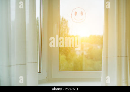 Window in the interior with curtains, on the glass drops of rain and a positive smiley Stock Photo