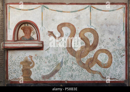 Mercury depicted in the Roman fresco in the lararium (Roman home shrine) of the House of the Cryptoporticus (Casa del Criptoportico) in the archaeological site of Pompeii (Pompei) near Naples, Campania, Italy. Mercury is depicted with his caduceus in a niche. Below: two snakes (the smaller wrapped around an altar), a peacock, and birds in a garden scene. Stock Photo