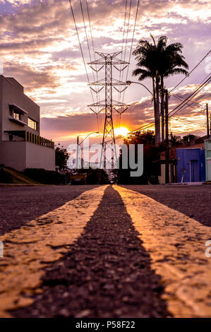 Street leading to a high voltage power tower against sunset sky Stock ...