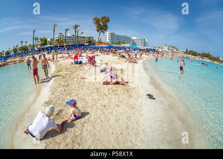 AYIA NAPA, CYPRUS - APRIL 07, 2018: People swimming and sunbathing on Nissi beach Stock Photo