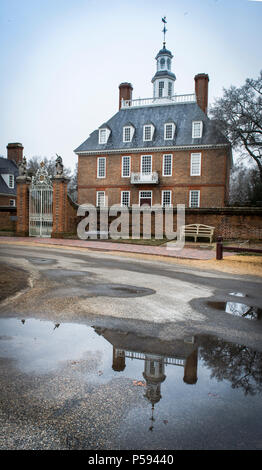 Historic reconstruction of the Governors Palace in Colonial Williamsburg reflected in a large puddle after a rain storm. Stock Photo