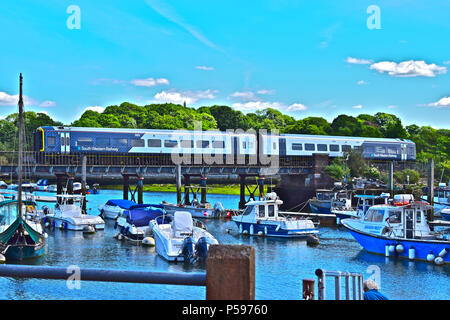 A South Western Railways train crosses the bridge over the River Lymington on it's way to the Isle of Wight ferry terminal in Lymington, Hampshire Stock Photo