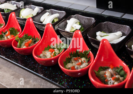 Table with cold snacks and fruits on stand and tableware on luxury stand-up party Stock Photo