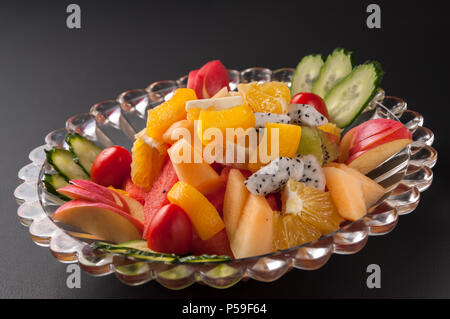 Colorful fruit platter with watermelon, cantaloupe, grapes, oranges, Dragon fruit and mint Stock Photo