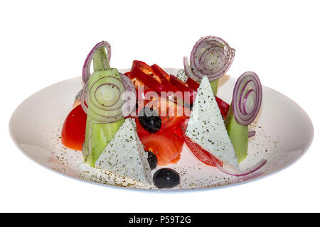 salad decoration. Tomatoes, sliced cucumbers, paprika, onion, black olives, cheese in ceramic plate, isolated on white background. Stock Photo