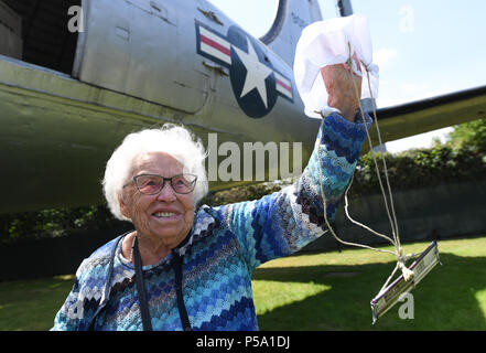 Frankfurt am Main, Germany. 26th June, 2018. The contemporary witness Gisela Raineri holds a tiny parachute with a piece of chocolate during the 70th jubilee of the Berlin air bridge at the memorial site at the Frankfurt Airport. The air bridge served as the supply of West Berlin through the western Allies during the Berlin blockade through the soviet occupation force from the 24th of June 1948 until the 12th of May 1949. Photo: Arne Dedert/dpa  Stock Photo