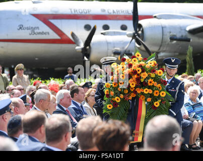 Frankfurt am Main, Germany. 26th June, 2018. A flower wreath is carried past the guests of honor during the 70th jubilee of the Berlin air bridge at the memorial site at the Frankfurt Airport. The air bridge served as the supply of West Berlin through the western Allies during the Berlin blockade through the soviet occupation force from the 24th of June 1948 until the 12th of May 1949. Photo: Arne Dedert/dpa  Stock Photo