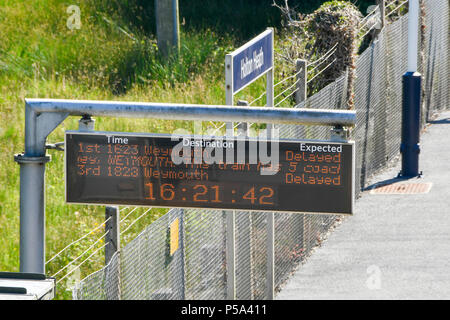 Holton Heath Station, Dorset, UK.  26th June 2018. UK Weather.   The station information sign at Holton Heath station showing delays on South Western Railways line in Dorset after a small fire under a train between Surbiton and Weybridge blocked the line.  This incident is on top of the speed restrictions on the railways due to the risk of the lines buckling due to the hot temperatures from the current heatwave.  Picture Credit: Graham Hunt/Alamy Live News Stock Photo